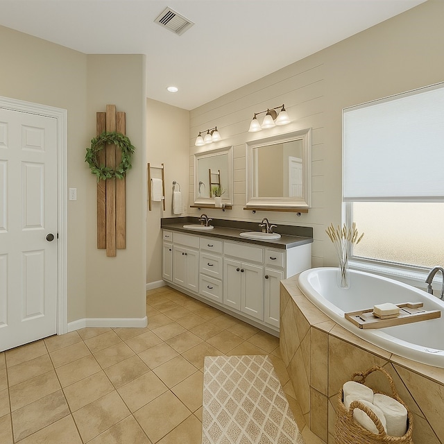 bathroom with tile patterned flooring, a garden tub, double vanity, and baseboards