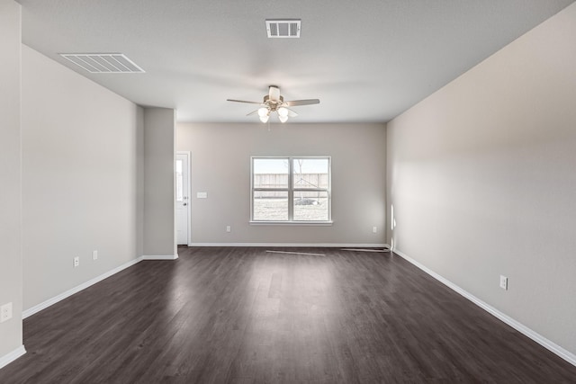 empty room featuring a ceiling fan, dark wood-style flooring, and baseboards