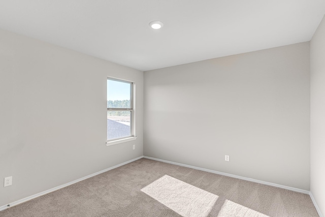 carpeted spare room with baseboards