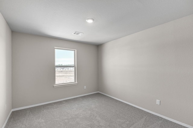 carpeted spare room featuring baseboards