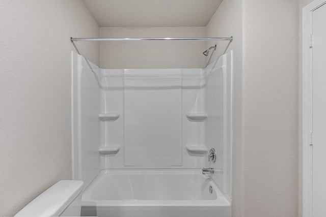 full bathroom featuring a textured wall, toilet, and tub / shower combination