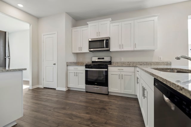 16430 Blossom Grove Dr, Conroe, TX 77303 - kitchen with stainless steel appliances, a sink, white cabinetry, dark wood-type flooring, and recessed lighting
