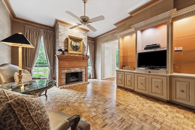 living area featuring crown molding, a ceiling fan, a brick fireplace, and baseboards
