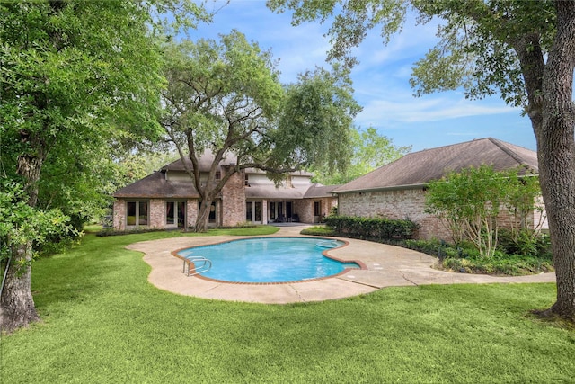 view of pool featuring a yard and a patio