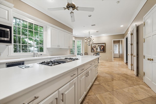 kitchen featuring appliances with stainless steel finishes, crown molding, white cabinets, light countertops, and a chandelier