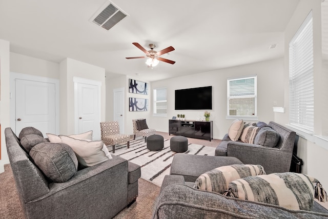 carpeted living room featuring a ceiling fan and healthy amount of natural light