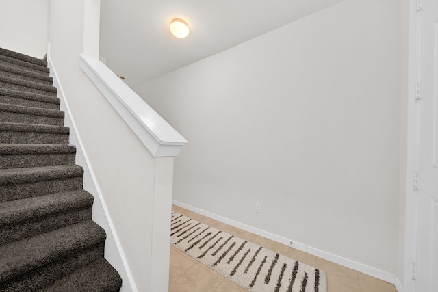 stairs featuring tile patterned floors and baseboards