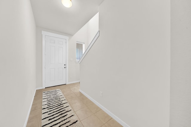 doorway to outside featuring light tile patterned floors and baseboards