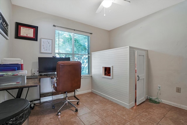 office space with a ceiling fan, baseboards, and light tile patterned flooring
