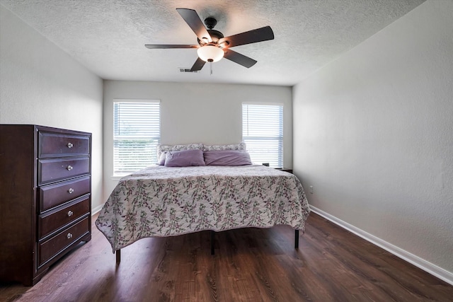 bedroom with baseboards, a textured ceiling, wood finished floors, multiple windows, and a ceiling fan