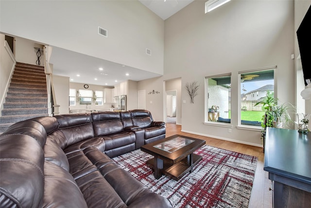 22110 Sam Raburn Dr, Tomball, TX 77375 - living room featuring stairway, light wood-style floors, a high ceiling, and baseboards