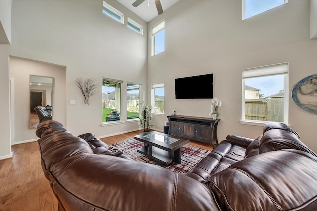 22110 Sam Raburn Dr, Tomball, TX 77375 - living room featuring a high ceiling, a ceiling fan, light wood finished floors, and baseboards