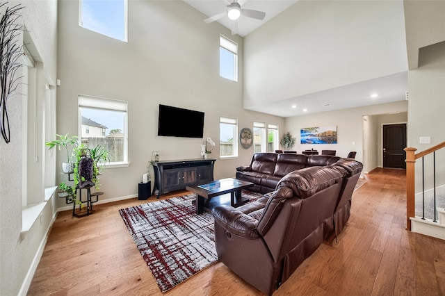 22110 Sam Raburn Dr, Tomball, TX 77375 - living room featuring a high ceiling, wood-type flooring, a ceiling fan, baseboards, and stairway
