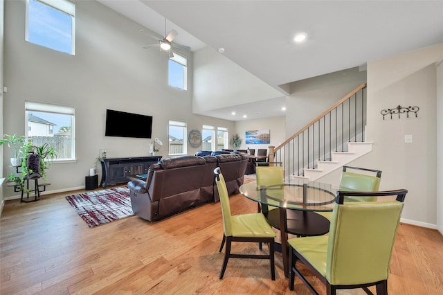 22110 Sam Raburn Dr, Tomball, TX 77375 - dining room featuring a towering ceiling, a ceiling fan, light wood-style flooring, healthy amount of natural light, and baseboards