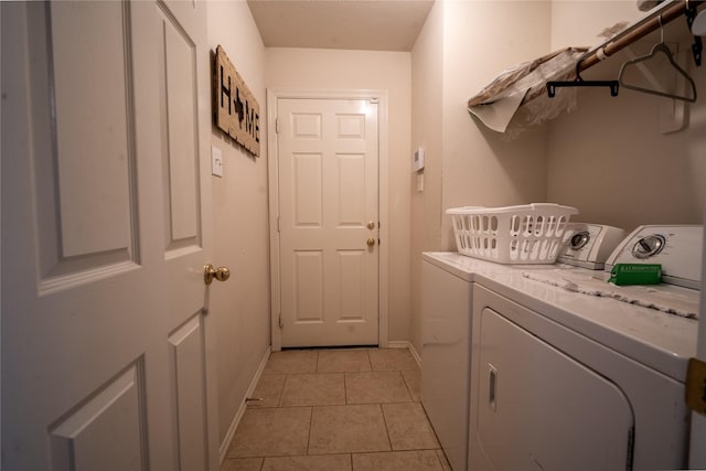 32102 Annice Ln, Pinehurst, TX 77362 - laundry room with washing machine and clothes dryer, light tile patterned floors, and baseboards