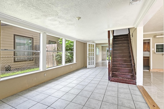 interior space featuring tile patterned floors, crown molding, and a textured ceiling