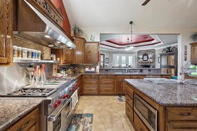 2014 Fish Lake Rd, Kountze, TX 77625 - kitchen with ventilation hood, stainless steel appliances, a raised ceiling, brown cabinets, and ceiling fan