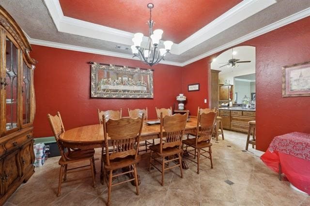 2014 Fish Lake Rd, Kountze, TX 77625 - dining area with a raised ceiling, crown molding, a chandelier, a ceiling fan, and arched walkways