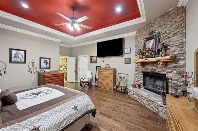 2014 Fish Lake Rd, Kountze, TX 77625 - bedroom featuring a tray ceiling, wood finished floors, a fireplace, ornamental molding, and recessed lighting