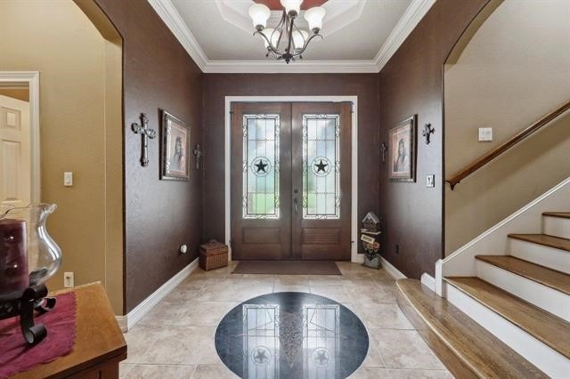 2014 Fish Lake Rd, Kountze, TX 77625 - foyer entrance with arched walkways, baseboards, a chandelier, french doors, and crown molding
