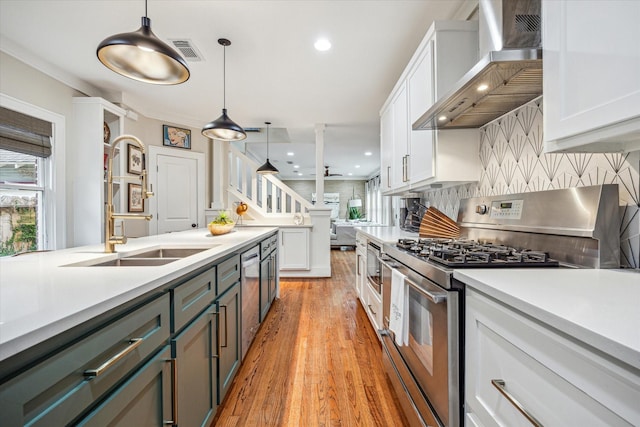 813 Key St, Houston, TX 77009 - kitchen featuring appliances with stainless steel finishes, wall chimney range hood, white cabinetry, light countertops, and recessed lighting