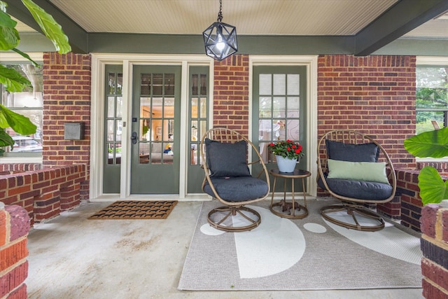 doorway to property with brick siding and covered porch
