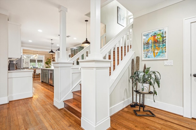 813 Key St, Houston, TX 77009 - stairs with wood finished floors, decorative columns, recessed lighting, baseboards, and a chandelier