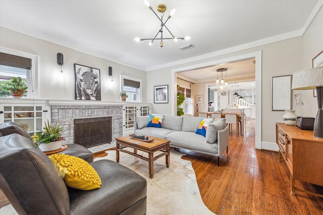 813 Key St, Houston, TX 77009 - living room with a chandelier, hardwood / wood-style floors, ornamental molding, a fireplace, and baseboards