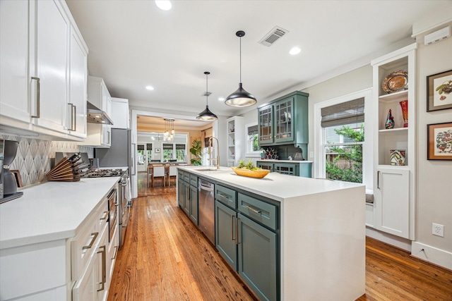 813 Key St, Houston, TX 77009 - kitchen featuring stainless steel appliances, a sink, light countertops, light wood-style floors, and recessed lighting