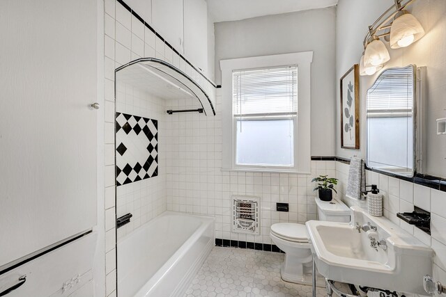 710 Woodland St, Houston, TX 77009 - full bath with heating unit, toilet, shower / bathtub combination, tile patterned floors, and tile walls