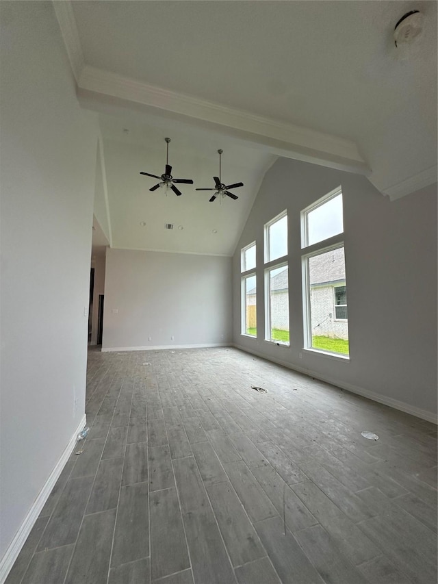 unfurnished living room with wood finished floors, baseboards, high vaulted ceiling, ceiling fan, and crown molding