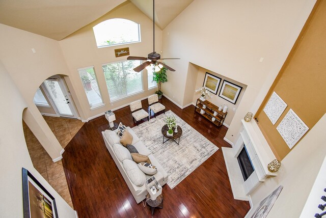 7003 Paxton Ct, Sugar Land, TX 77479 - living room featuring plenty of natural light, high vaulted ceiling, a fireplace, a ceiling fan, and wood finished floors