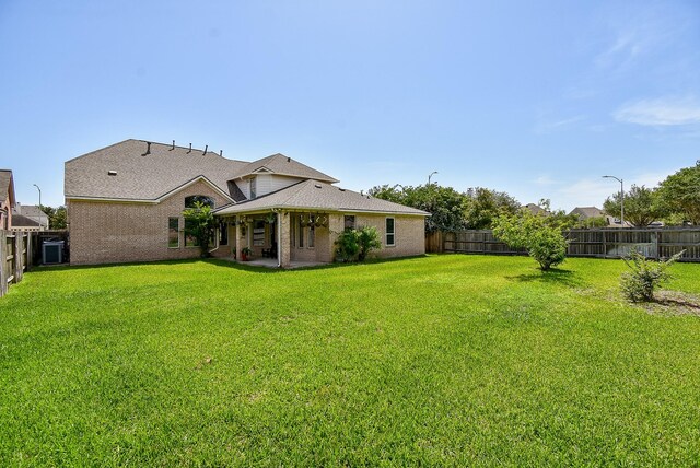 7003 Paxton Ct, Sugar Land, TX 77479 - back of house featuring a patio area, roof with shingles, and brick siding