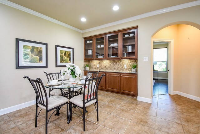 7003 Paxton Ct, Sugar Land, TX 77479 - dining area with arched walkways, crown molding, recessed lighting, light tile patterned floors, and baseboards