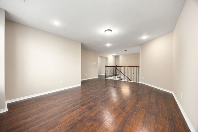 27106 Cottage Stream Ln, Fulshear, TX 77441 - empty room featuring dark wood-style flooring, baseboards, recessed lighting, and arched walkways