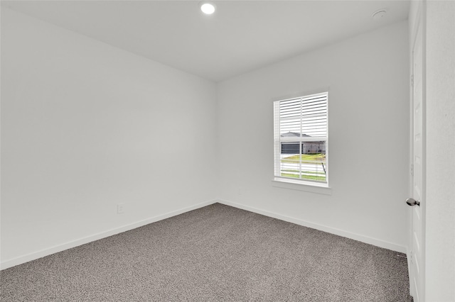 spare room featuring dark colored carpet, baseboards, and recessed lighting