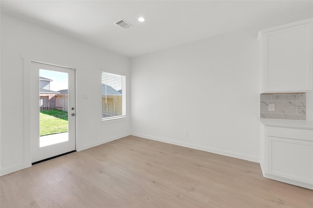 unfurnished room with light wood-type flooring, baseboards, and recessed lighting