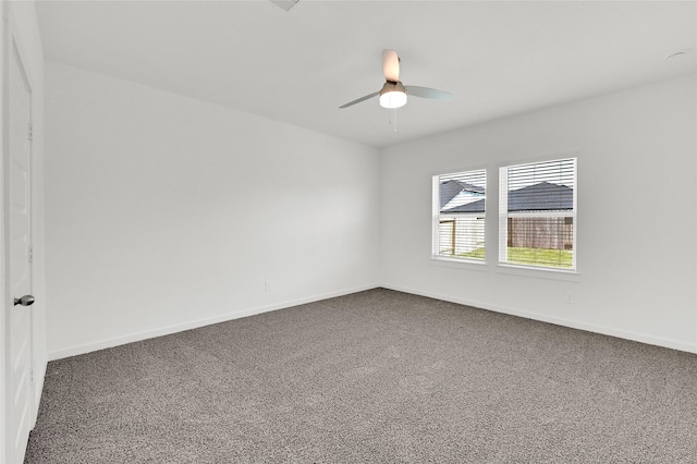carpeted empty room featuring ceiling fan and baseboards
