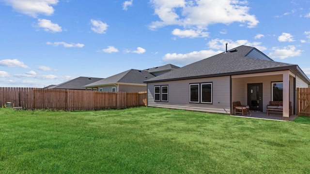 rear view of house with a shingled roof and a patio area