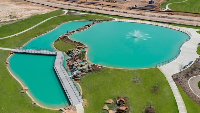 drone / aerial view of a pool and a nearby body of water