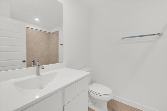 3907 Knighton Ct, Fulshear, TX 77441 - bathroom with vanity, baseboards, toilet, wood finished floors, and recessed lighting