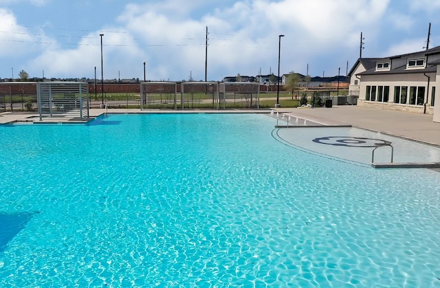 community pool featuring fence and a patio