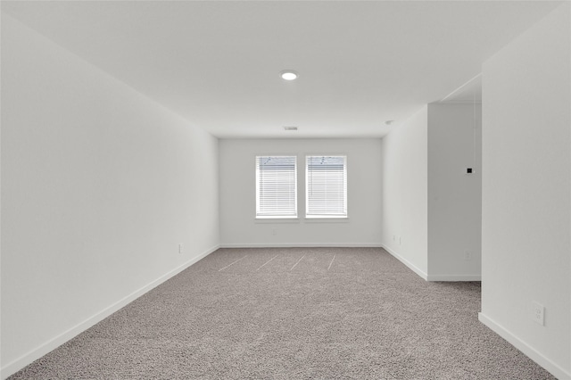 empty room featuring light colored carpet, baseboards, and recessed lighting
