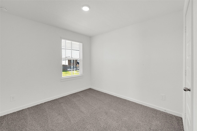 spare room with dark colored carpet, baseboards, and recessed lighting