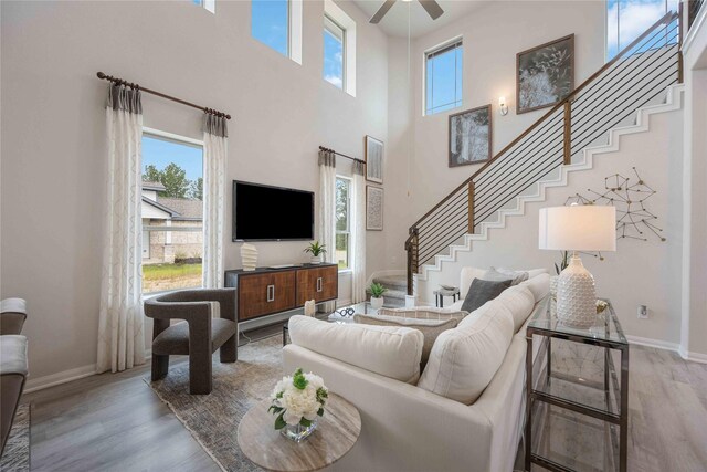 16809 Needlepoint Dr, Conroe, TX 77302 - living room featuring stairs, wood finished floors, baseboards, and a high ceiling