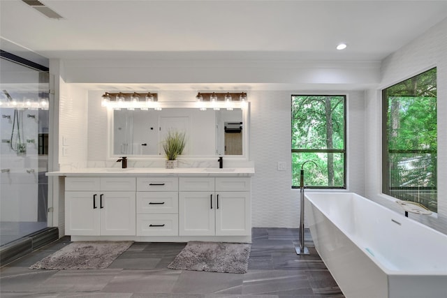 140 S Timber Top Dr, Spring, TX 77380 - bathroom with double vanity, a soaking tub, a stall shower, and recessed lighting