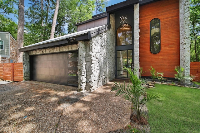 140 S Timber Top Dr, Spring, TX 77380 - view of property exterior with stone siding, driveway, an attached garage, and fence