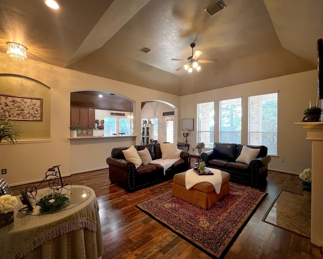 living area featuring ceiling fan, dark wood finished floors, arched walkways, baseboards, and lofted ceiling