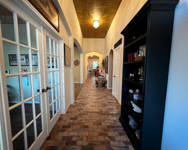 3002 Sandleigh Dr, Spring, TX 77388 - hall with arched walkways, french doors, brick floors, and baseboards