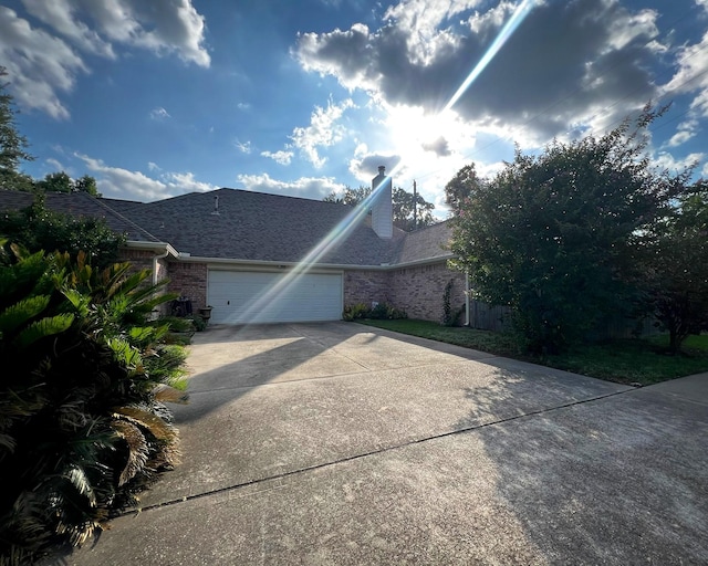 view of front of property featuring an attached garage, brick siding, concrete driveway, and roof with shingles